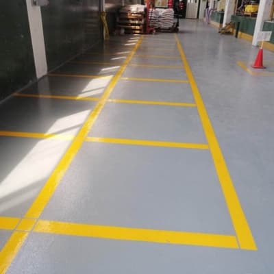 Yellow pedestrian walkway floor striping inside a warehouse