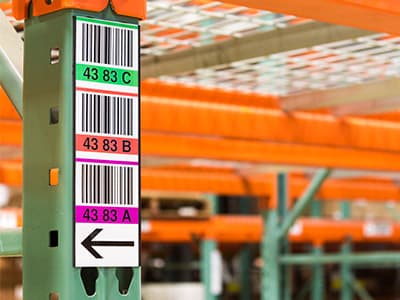 Vertical color-coded multilevel totem label on a warehouse rack upright
