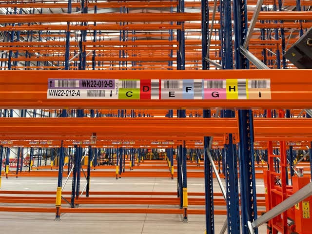 Barcode location label mounted on a warehouse rack beam