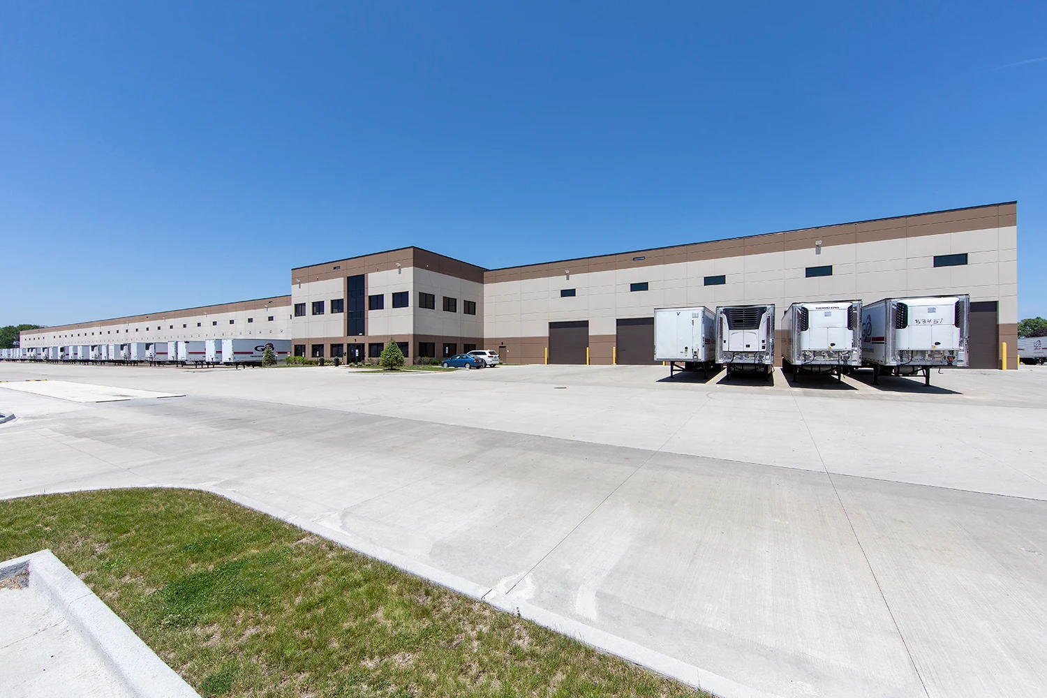 Wide industrial property facade with loading docks and an open truck court
