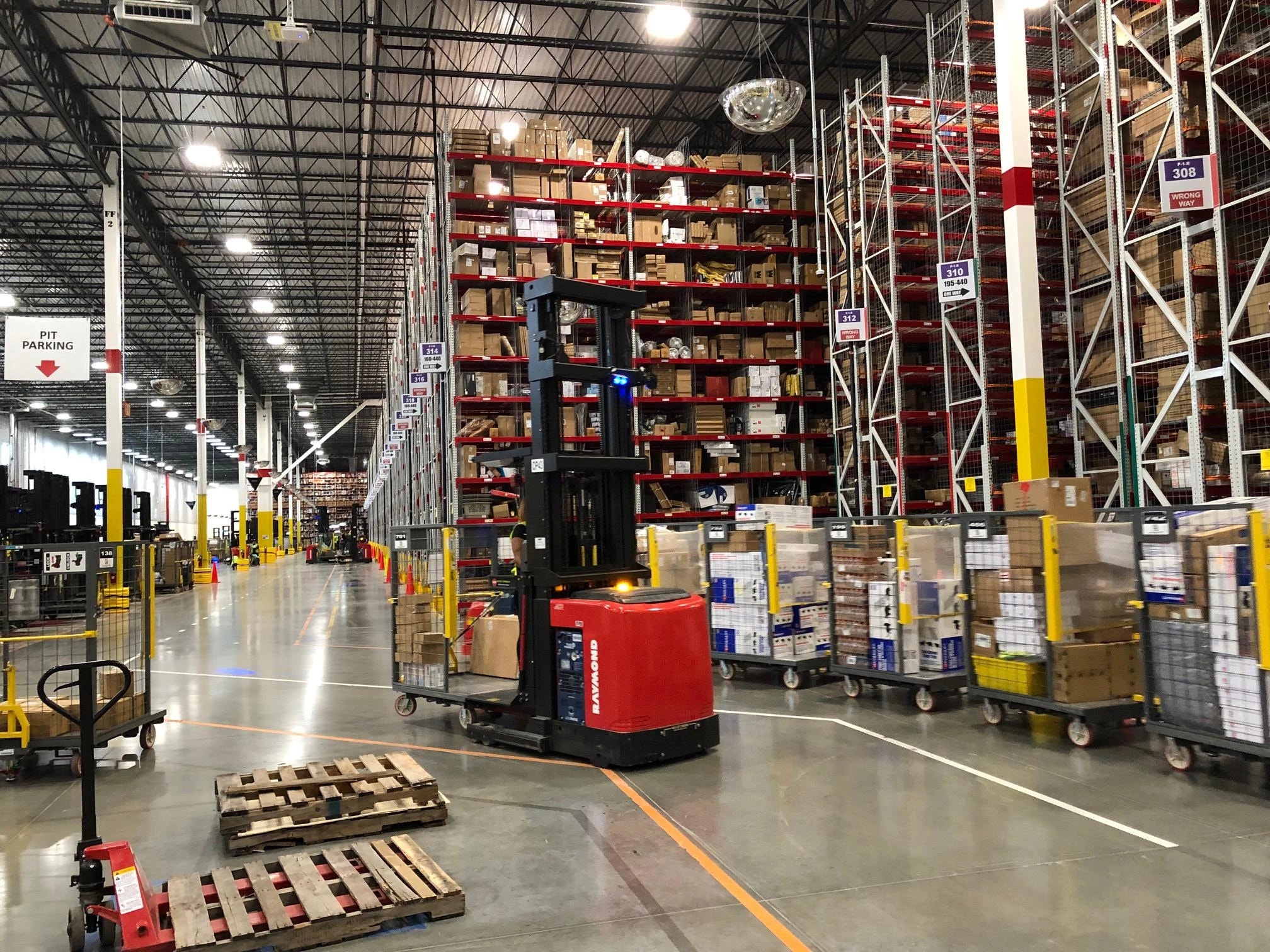Warehouse order-picking area with rack storage, reach trucks and organized material staging