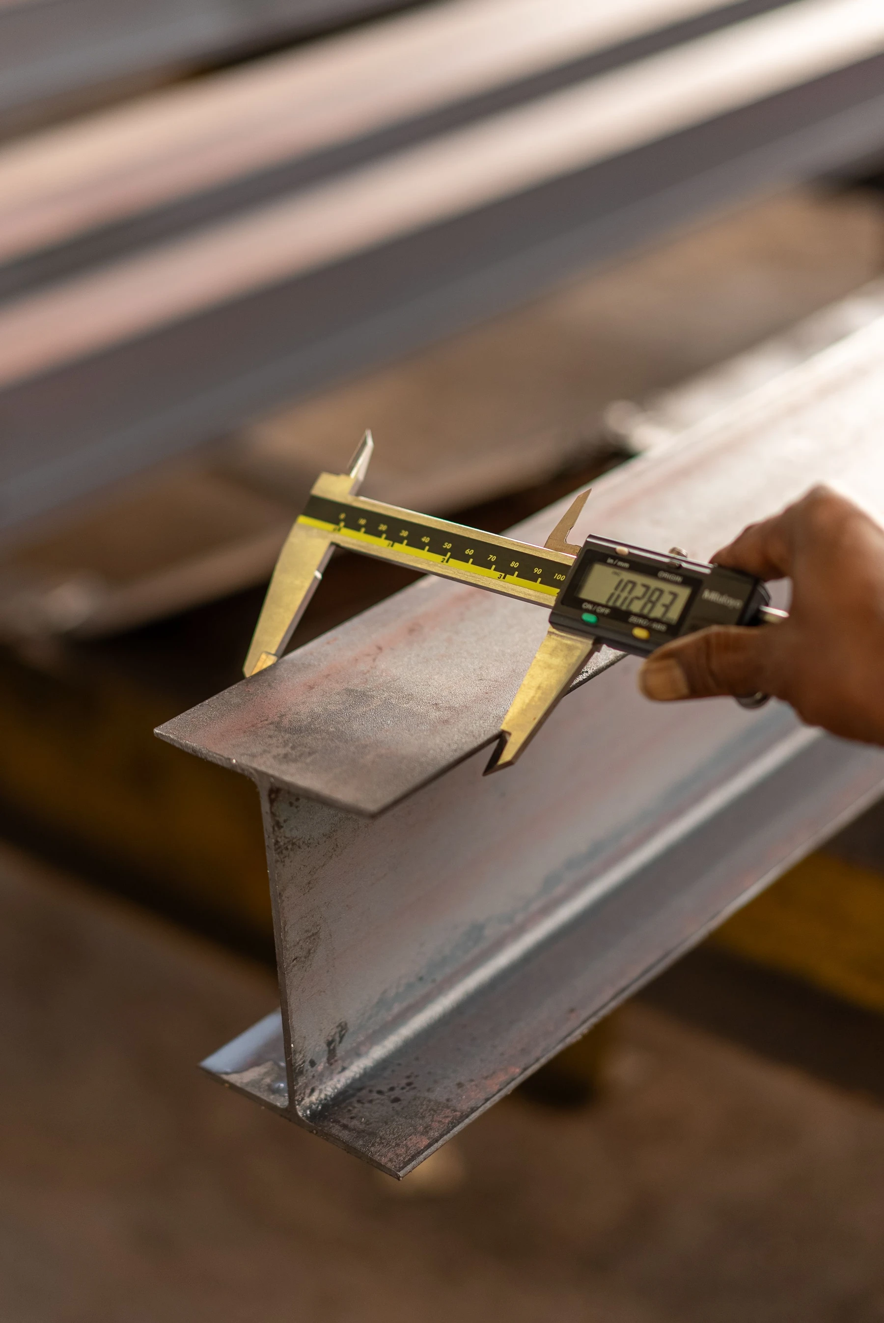 Caliper checking the dimensions of a steel member