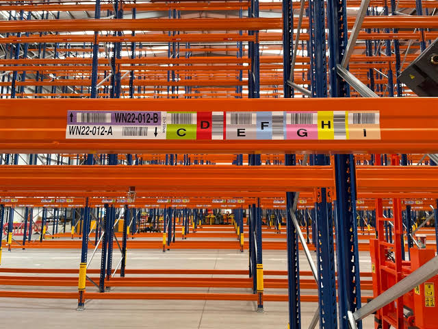 Barcode location label mounted on a warehouse rack beam