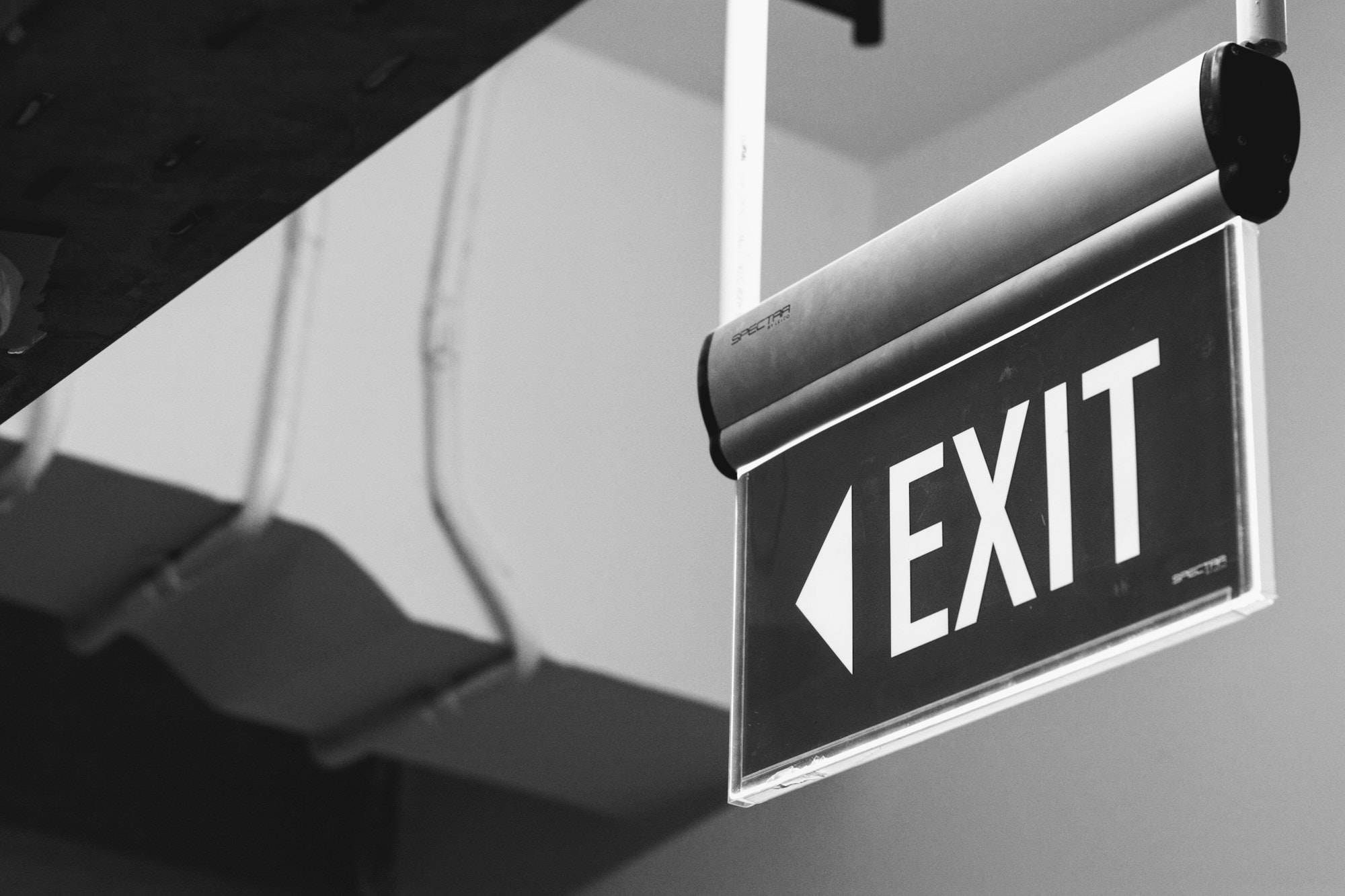 Exit wayfinding sign suspended from an interior ceiling