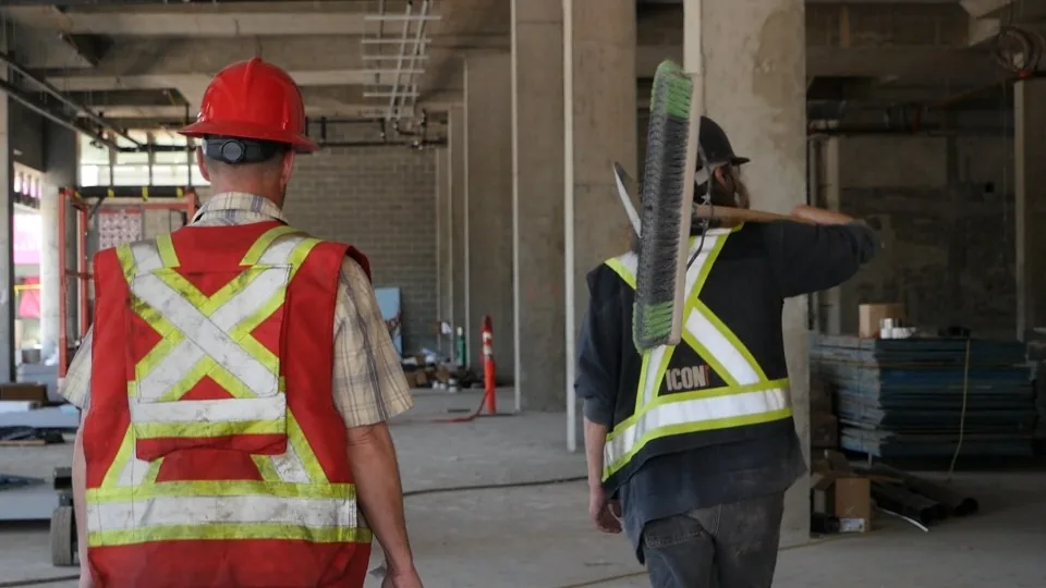 Workers moving through a commercial interior under renovation