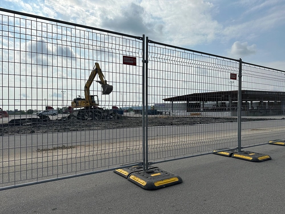 Freestanding mesh fence panels along an active construction site